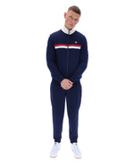 Man wearing a navy tracksuit with a brand logo on a white background