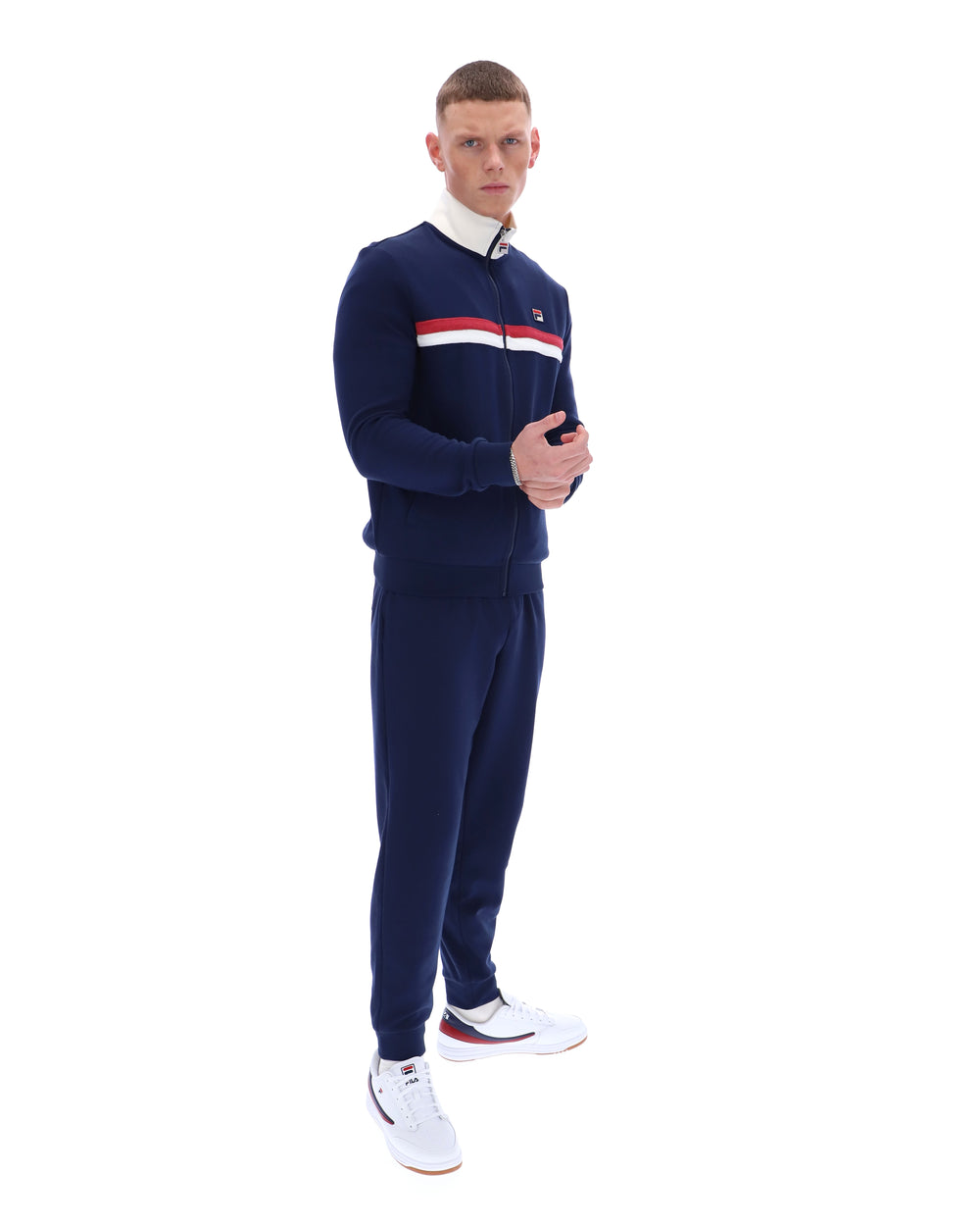 Man wearing a navy tracksuit with a red and white stripe on a white background
