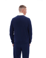 Man wearing a navy blue sweater and pants on a white background