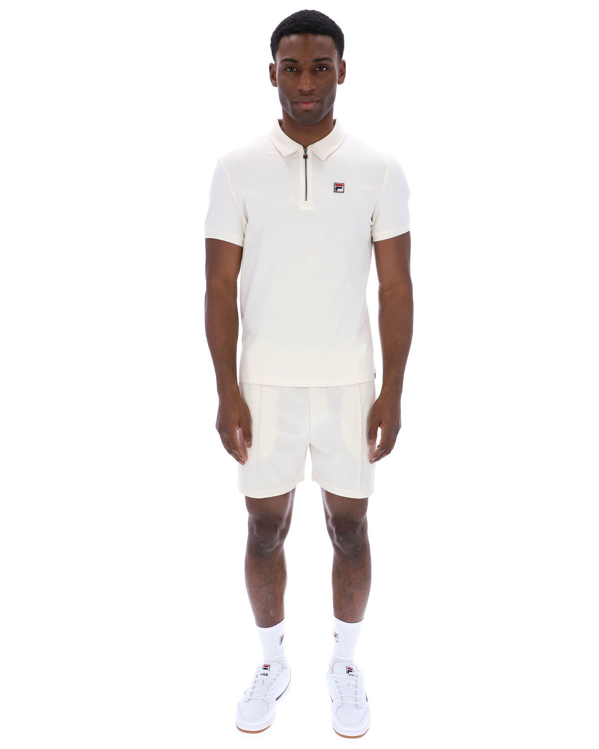 Displays a model wearing the Gardenia 'FILA' branded Ettore Zip Polo