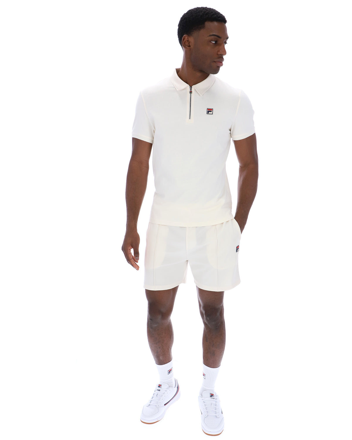 Displays a model wearing the Gardenia 'FILA' branded Ettore Zip Polo