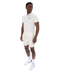 Displays a model wearing the Gardenia 'FILA' branded Ettore Zip Polo