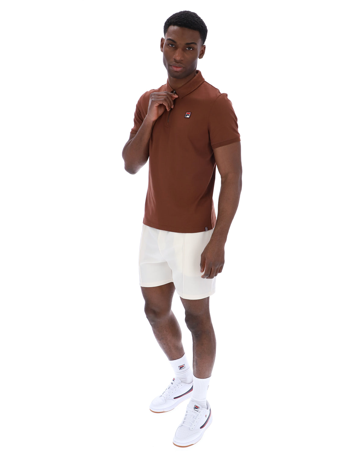 Man wearing a brown polo shirt and white shorts on a white background