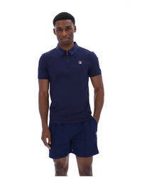 Displays a model wearing the Navy 'Fila' branded Ettore Zip Polo