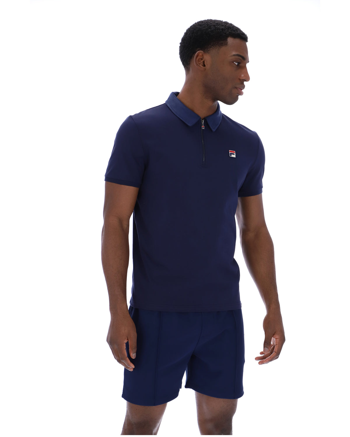 Displays a model wearing the Navy 'Fila' branded Ettore Zip Polo