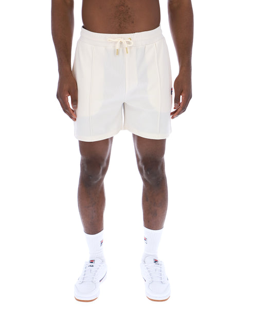 Displays a model wearing the Gardenia 'FILA' branded Eusebio Pin-Tuck Shorts