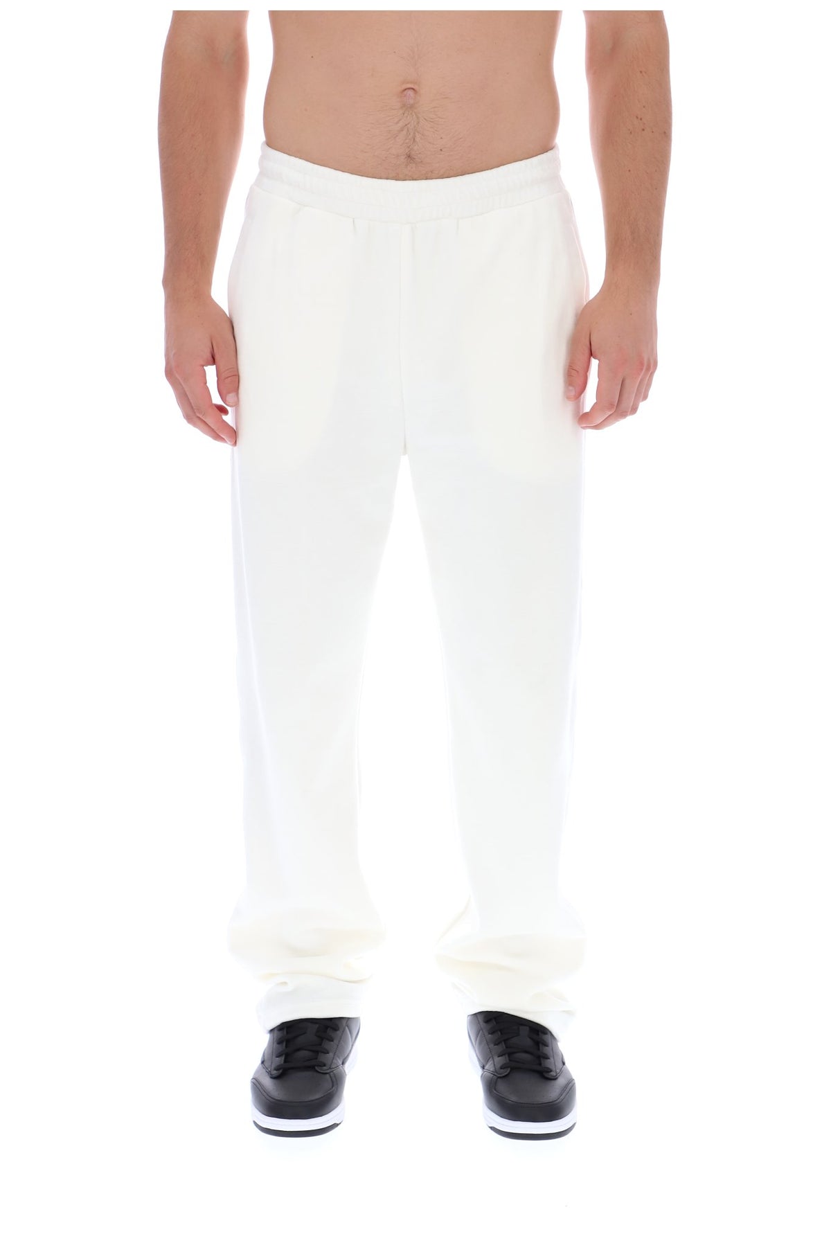 Displays a model wearing the White 'FILA' branded Down Fario Velour Track Pant