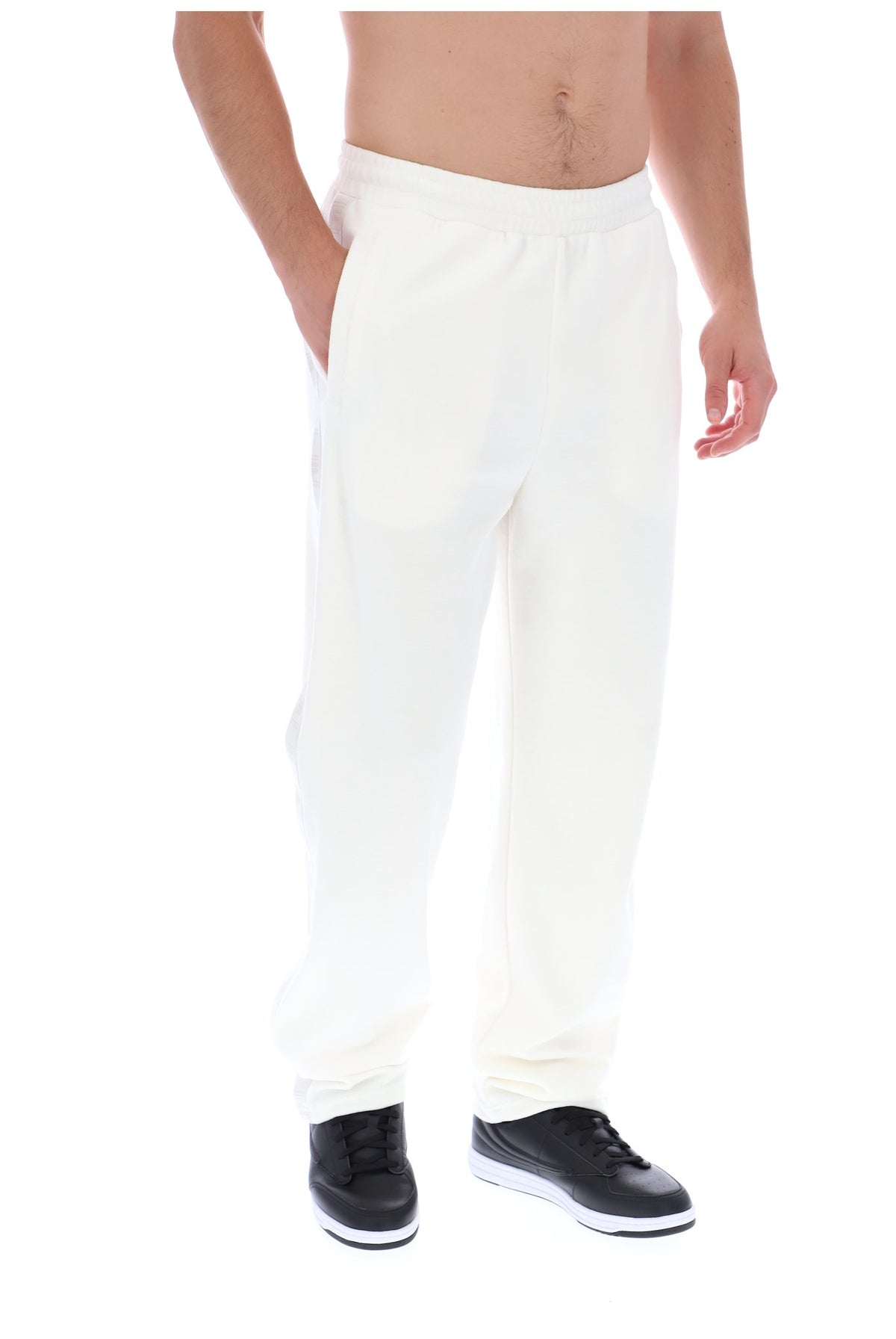 Displays a model wearing the White 'FILA' branded Down Fario Velour Track Pant