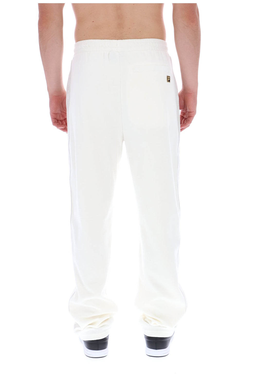 Displays a model wearing the White 'FILA' branded Down Fario Velour Track Pant