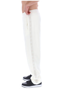 Displays a model wearing the White 'FILA' branded Down Fario Velour Track Pant