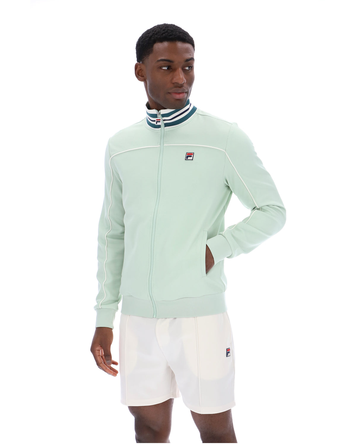 Person wearing a light green jacket with a brand logo on a white background