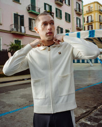 Displays a model wearing the Coconut Milk 'FILA' branded Teddy Knitted Shirt