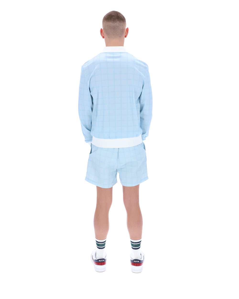 Person wearing a light blue outfit with shorts on a white background