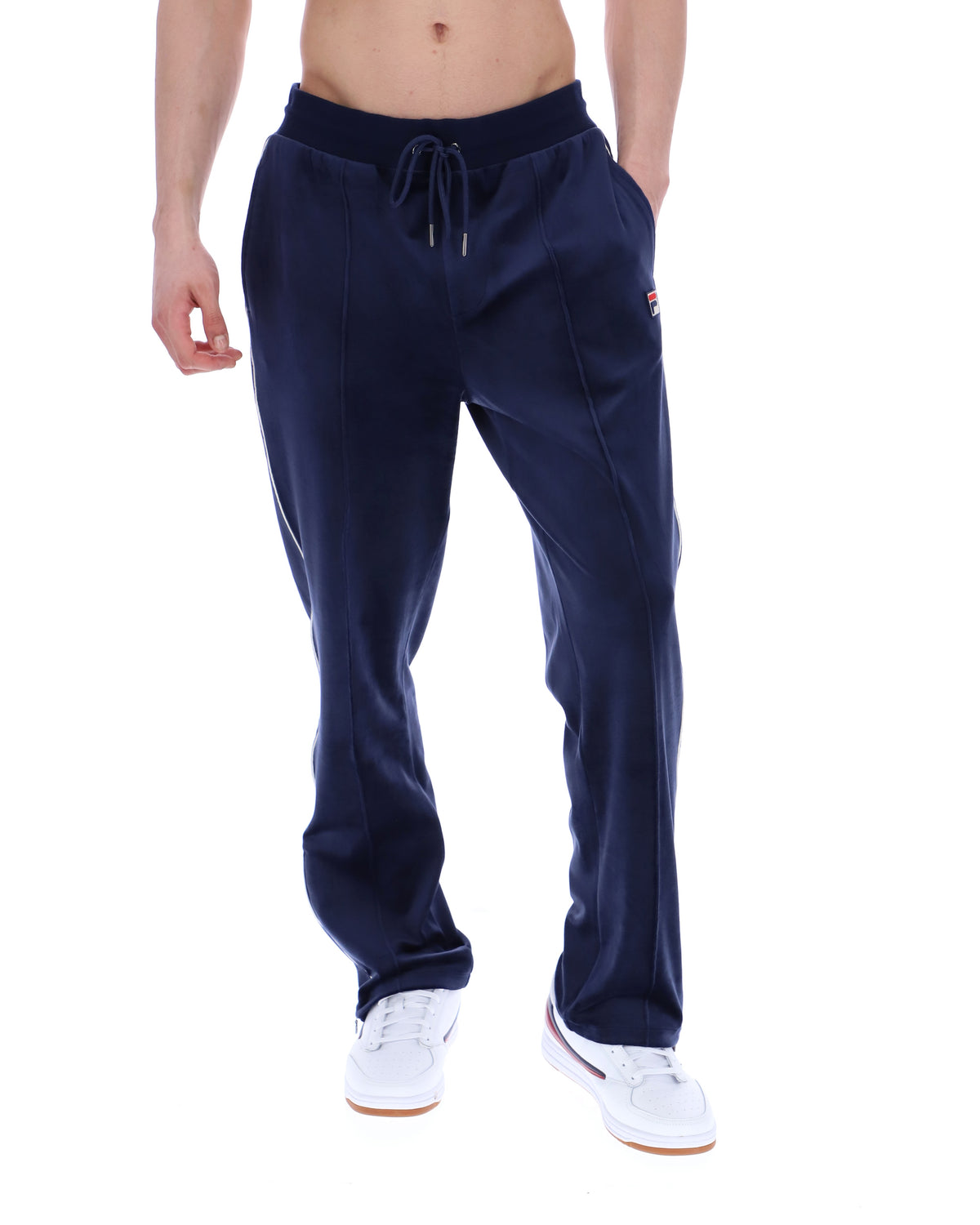Navy blue sweatpants with a FILA logo, worn by a person on a white background