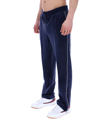 Navy track pants with a white stripe on a white background