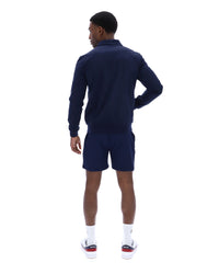 Man wearing a navy track jacket and shorts on a white background