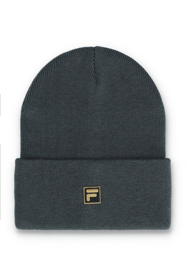 A dark gray ribbed knit beanie hat with a folded cuff and a small gold-tone Fila logo patch on the front, shown against a plain white background.
