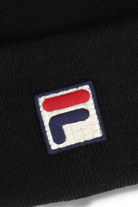 Close-up of a black knit beanie featuring an embroidered square patch with the Fila logo in red, white, and navy blue.