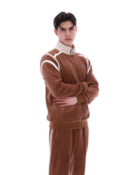 Man wearing a brown tracksuit with white stripes on a white background