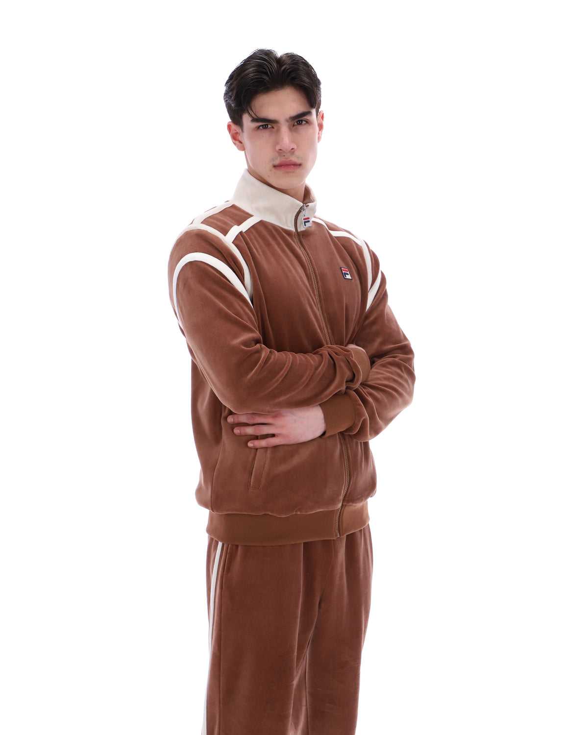 Man wearing a brown tracksuit with white stripes on a white background