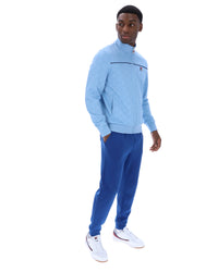 Man wearing a light blue tracksuit with a white background