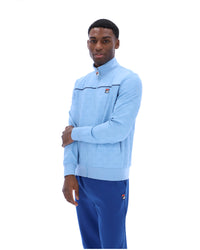 Man wearing a light blue jacket and blue pants on a white background