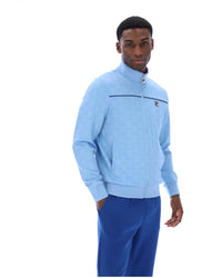 Man wearing a light blue sweater and blue pants on a white background