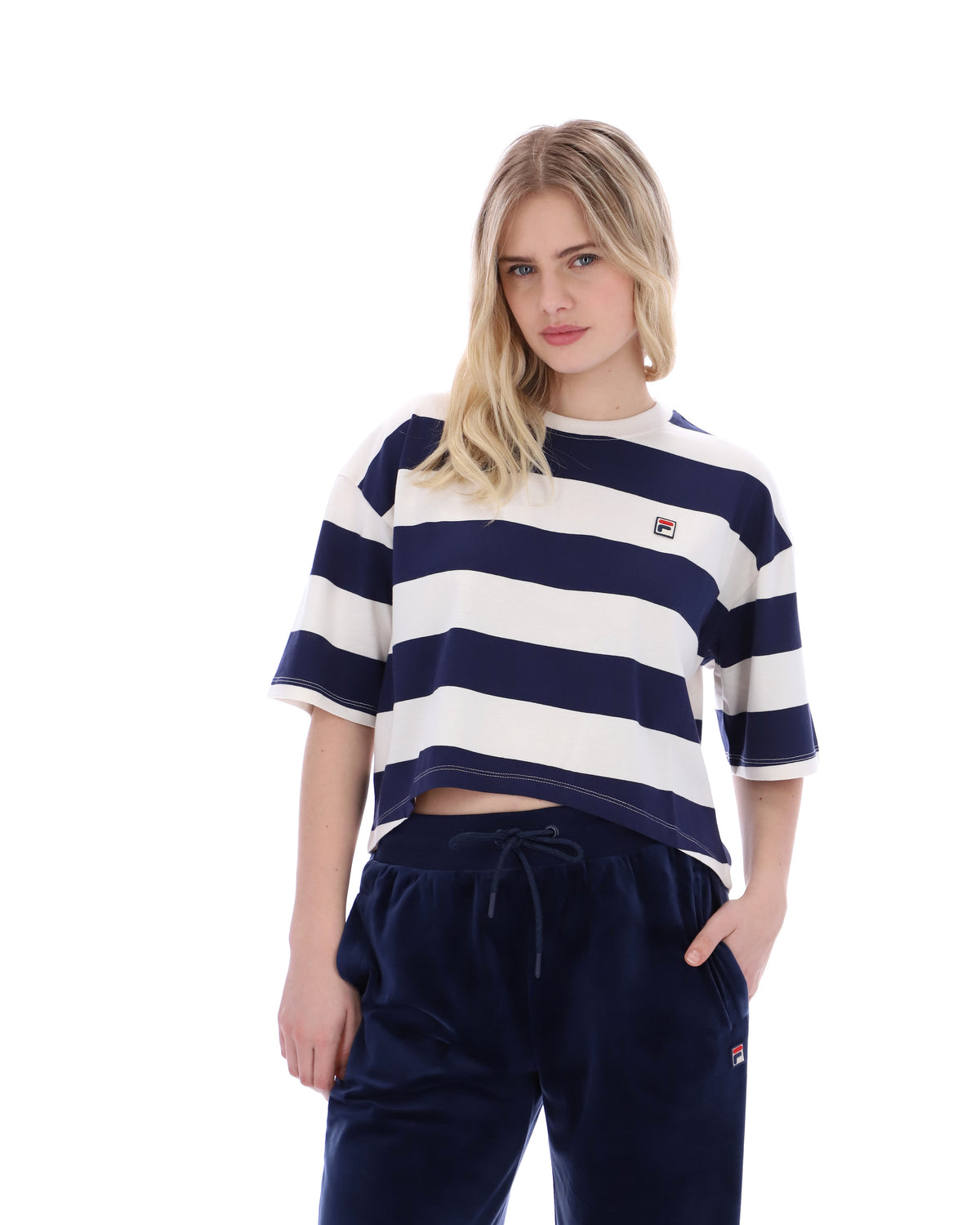 Woman wearing a navy and white striped shirt with a FILA logo on the chest, standing against a white background.