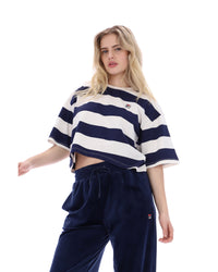 Woman wearing a navy and white striped crop top with matching pants on a white background
