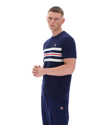 Man wearing a Navy blue t-shirt with white and red stripes and Fila logo with matching joggers on a white background
