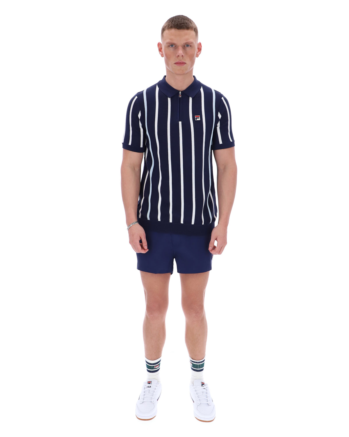 Man wearing a navy and white striped polo shirt with matching shorts on a white background
