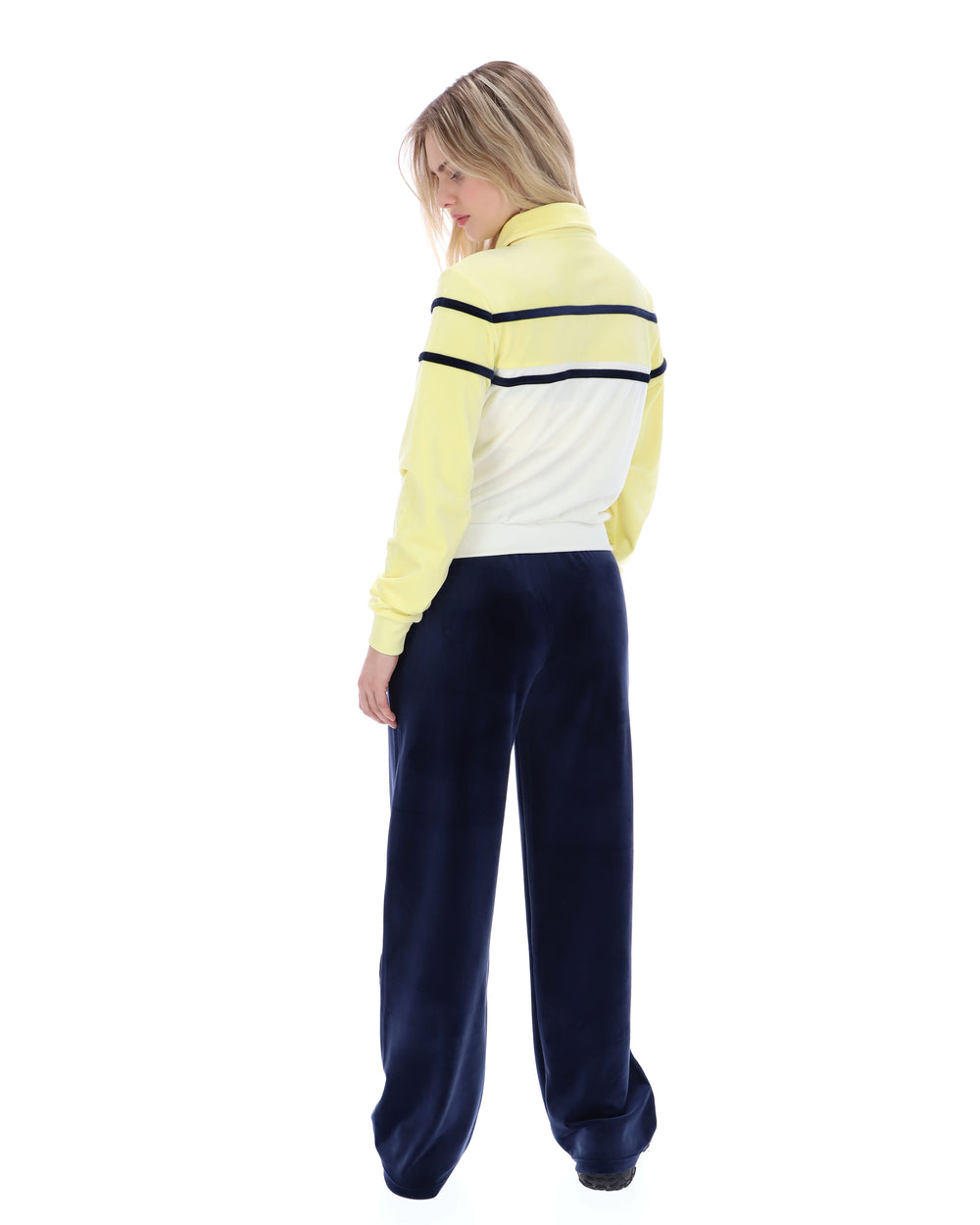 Person wearing a yellow and navy tracksuit on a white background