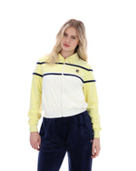Woman wearing a yellow and white jacket with navy pants on a white background