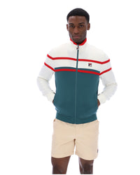 Man wearing a green and white track top with red detailing, with a FILA logo on the chest, paired with beige FILA shorts, against a white background