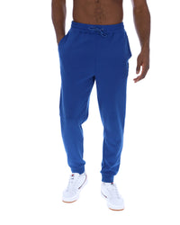 Blue sweatpants worn by a person on a white background