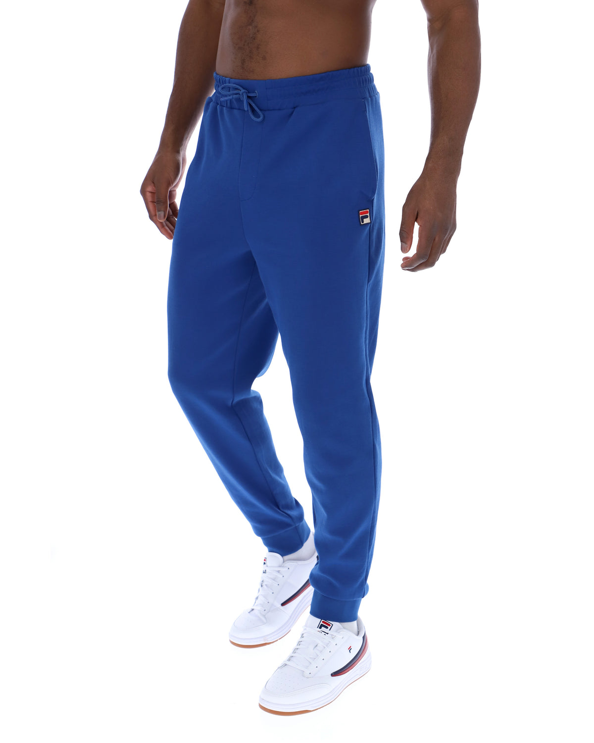 Person wearing blue sweatpants with a brand logo on a white background
