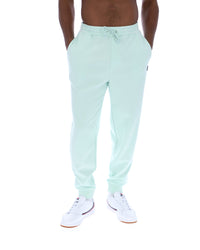 Person wearing light green sweatpants on a white background
