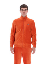 A man wearing a bright orange corduroy zip-up jacket and matching orange corduroy pants against a plain white background.