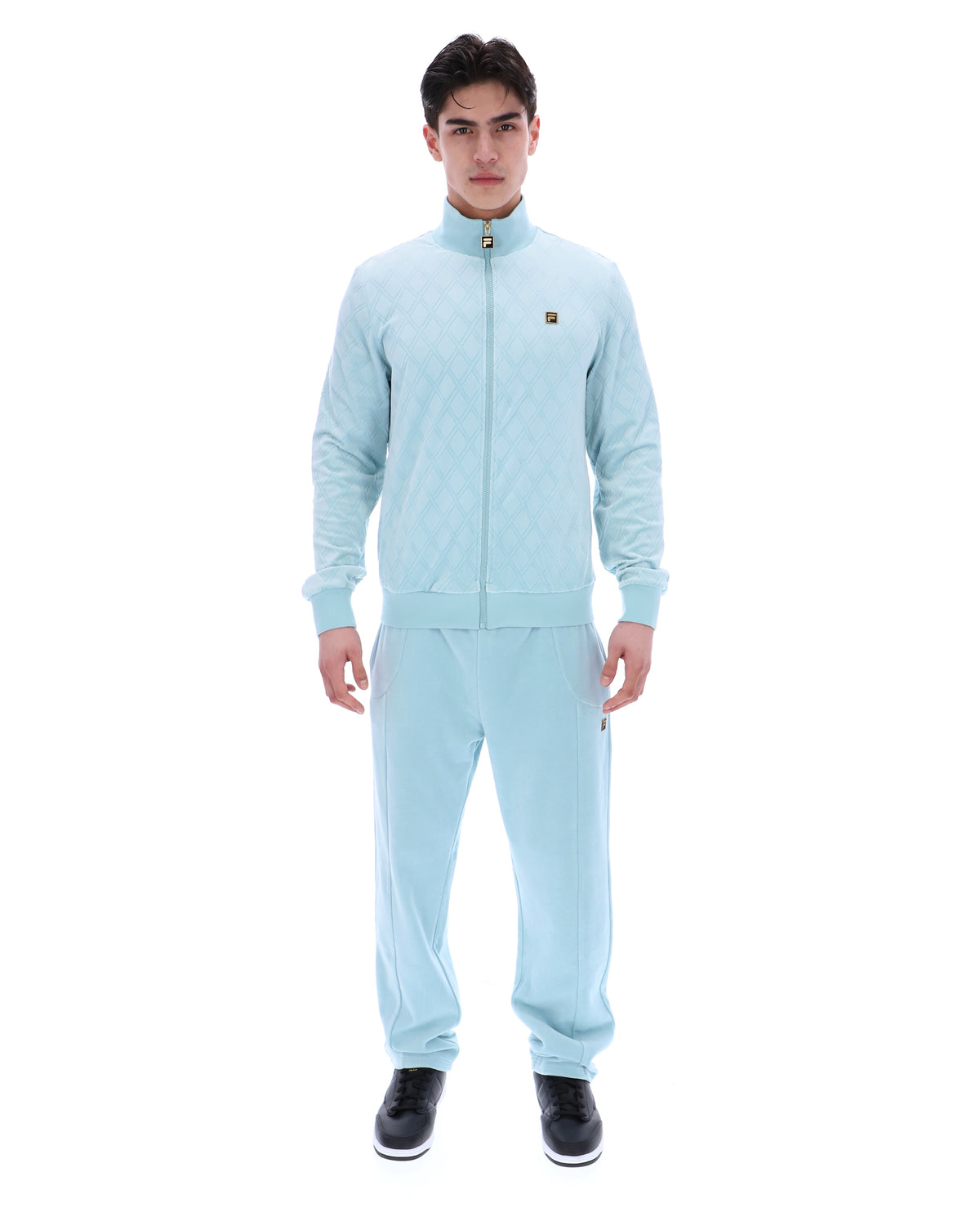 Man wearing a light blue tracksuit on a white background