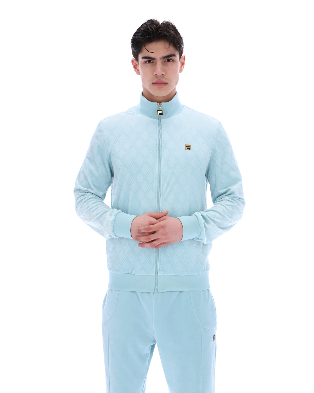 Man wearing a light blue tracksuit on a white background