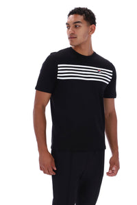 A man wearing a black short-sleeve crewneck t-shirt with a horizontal white stripe pattern across the chest and a small red and white logo on the right chest, paired with black pants, against a plain white background.