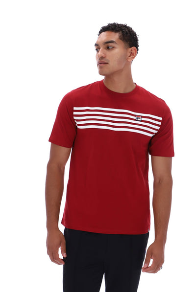 A man wearing a red short-sleeve crewneck t-shirt with a horizontal stripe pattern across the chest, paired with black pants, photographed against a solid white background.
