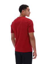 A man wearing a solid red short-sleeve crewneck t-shirt, shown from a three-quarters back view against a plain white background.