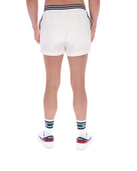 Person wearing white shorts with a striped waistband on a white background