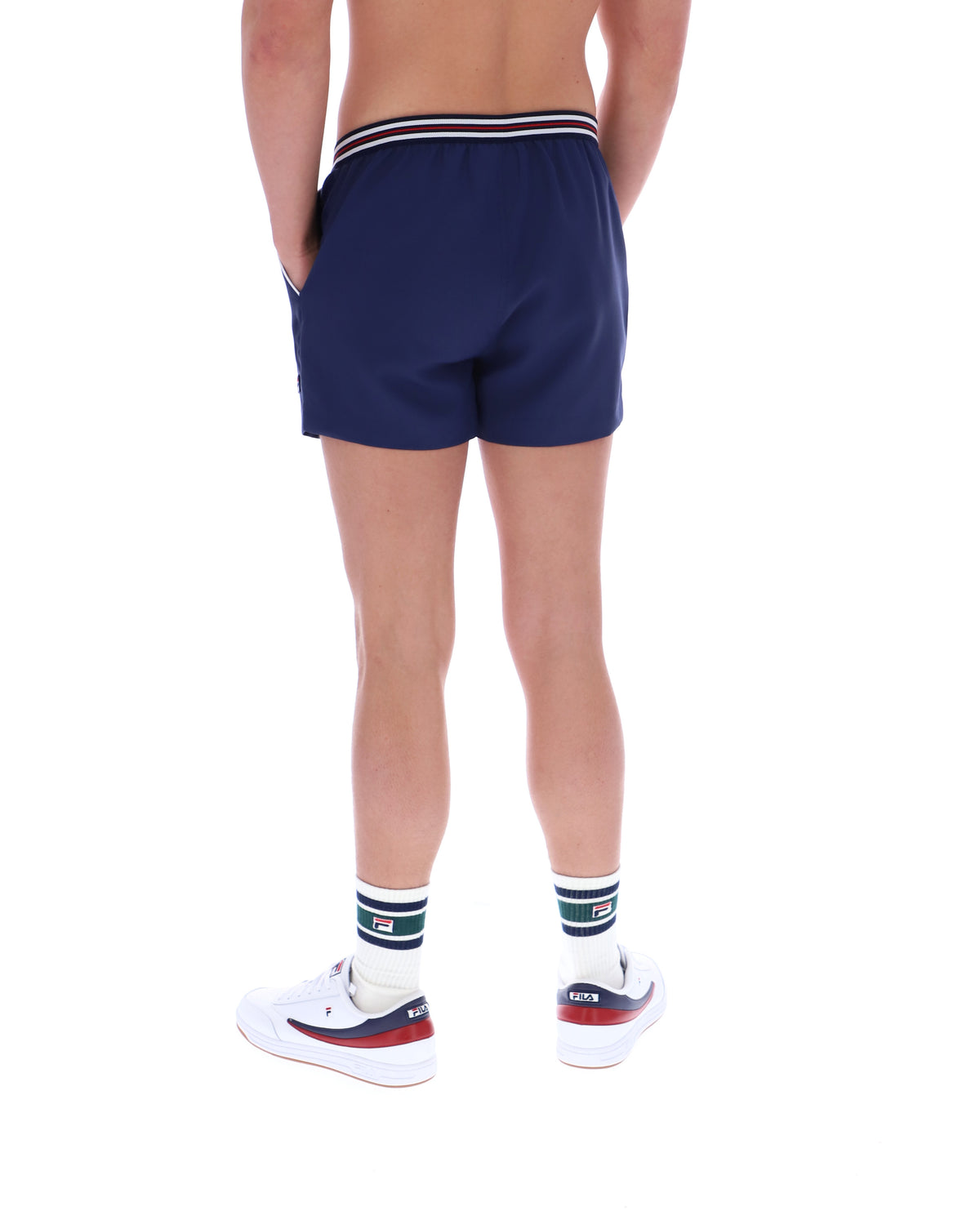Person wearing navy shorts with a striped waistband on a white background