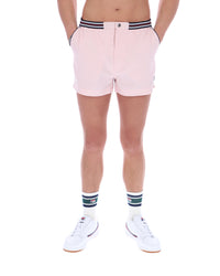 Person wearing light pink shorts with a striped waistband on a white background