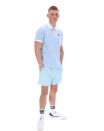 Man wearing a light blue striped polo shirt and shorts set on a white background