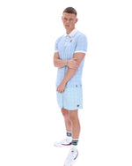 Person wearing a light blue striped polo shirt and shorts on a white background