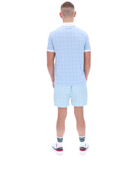 Person wearing a light blue checkered outfit on a white background