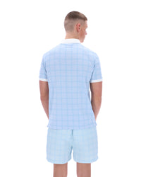 Man wearing a light blue checkered shirt and shorts set on a white background